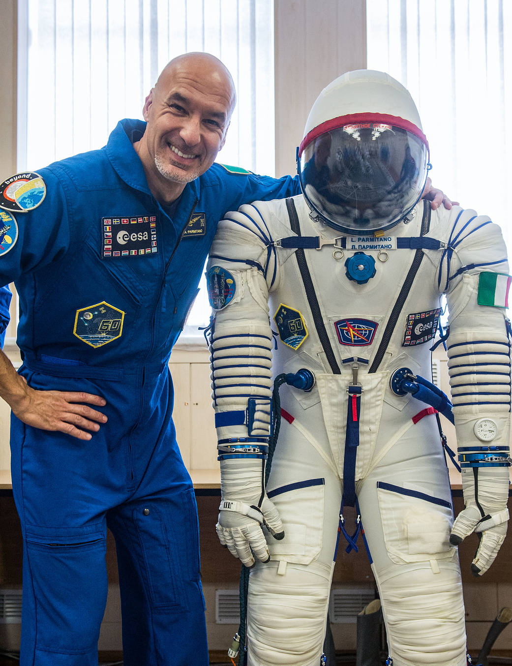 Expedition 60 crewmember Luca Parmitano poses with his Sokol launch and entry suit