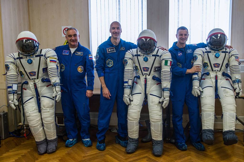 Expedition 60 crewmembers pose for pictures with their Sokol launch and entry suits