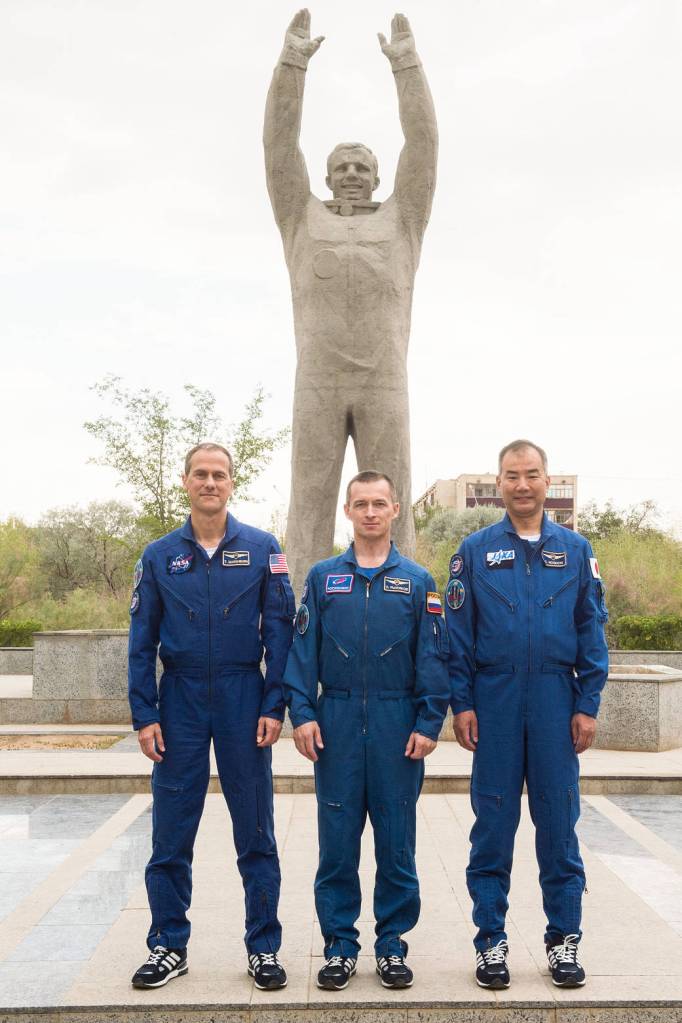 Expedition 60 backup crewmembers in front of the statue of Yuri Gagarin