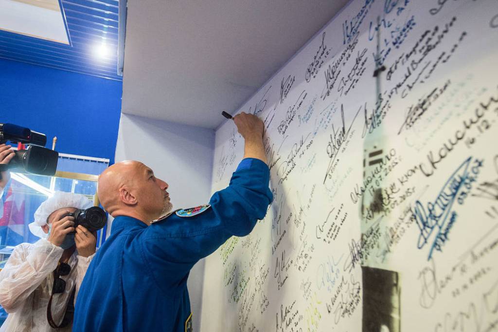 Expedition 60 crewmember Luca Parmitano signs a wall mural