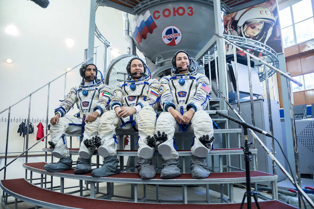 Spaceflight participant Hazzaa Ali Almansoori, Oleg Skripochka and Jessica Meir listen to reporters’ questions during crew quali