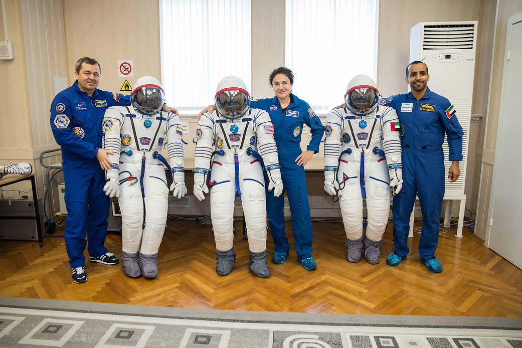 Oleg Skripochka, Jessica Meir and Hazzaa Ali Almansoori pose for pictures with their Russian Sokol launch and entry suits