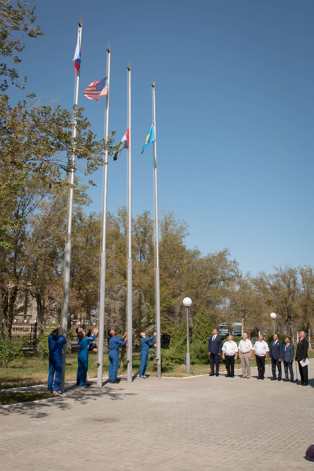 The prime and backup crewmembers for the next launch to the space station raise the flags 