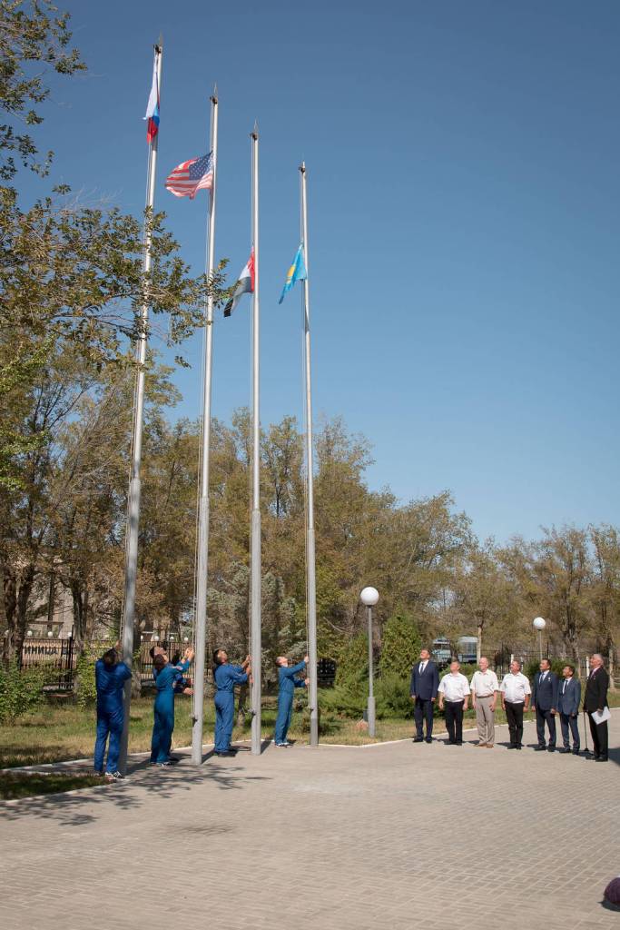 The prime and backup crewmembers for the next launch to the space station during a flag-raising ceremony