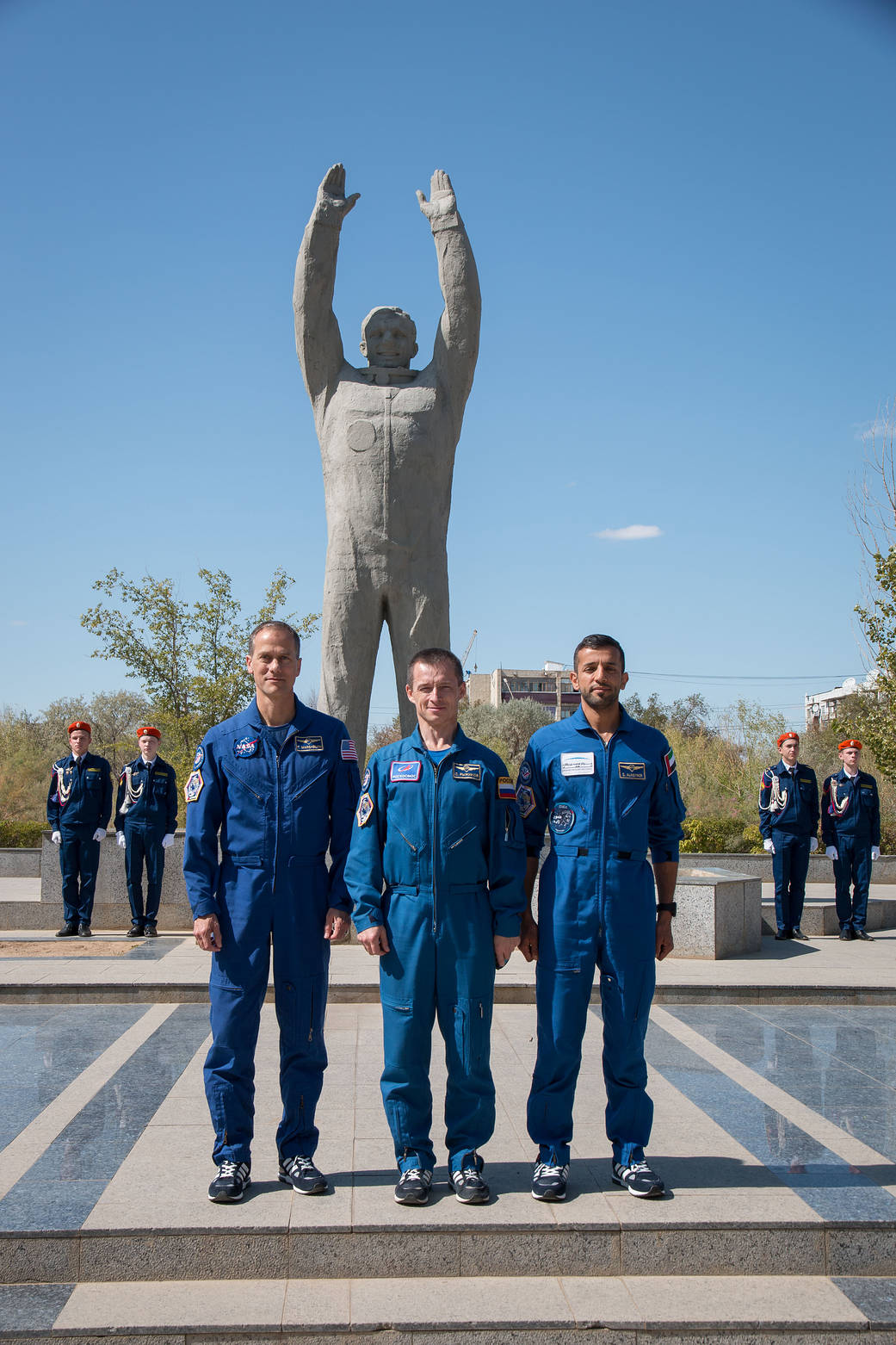 The backup crewmembers for the next launch to the space station in front of a statue of Yuri Gagarin