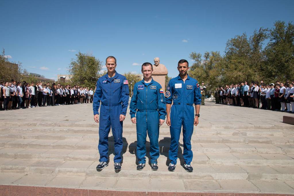 The backup crewmembers for the next launch to the space station in front of a statue of Sergei Korolev