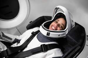 NASA astronaut Jessica Watkins flashes a smile while wearing a SpaceX spacesuit with the helmet visor up.