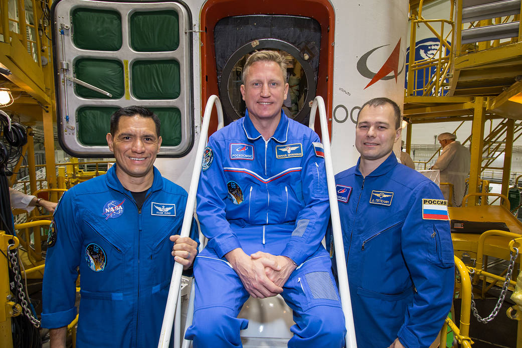 The Soyuz MS-22 crew poses in front of the spacecraft