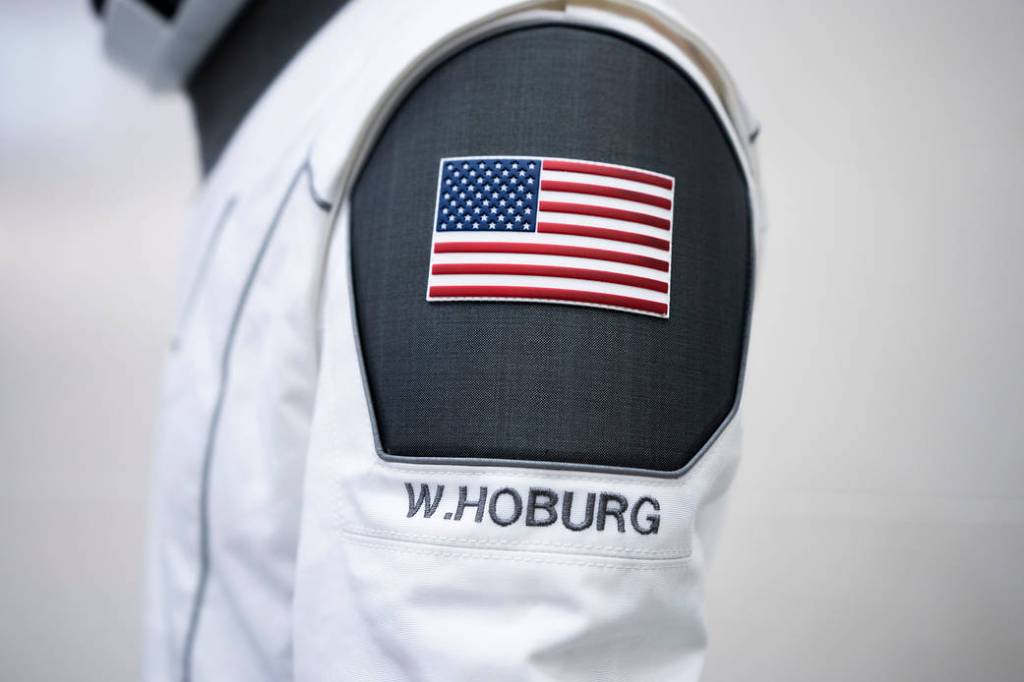 A SpaceX launch and entry suit bears an American flag