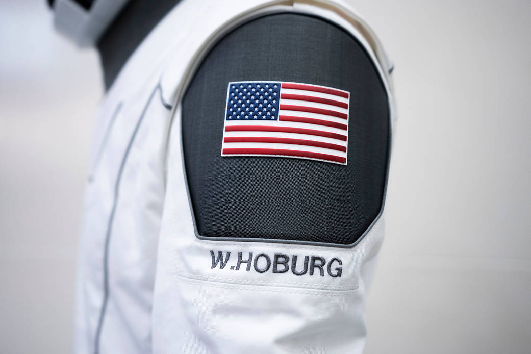 A SpaceX launch and entry suit bears an American flag