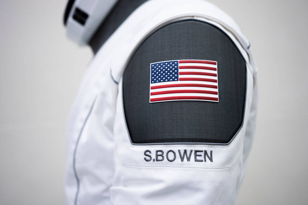 A SpaceX launch and entry suit bears an American flag