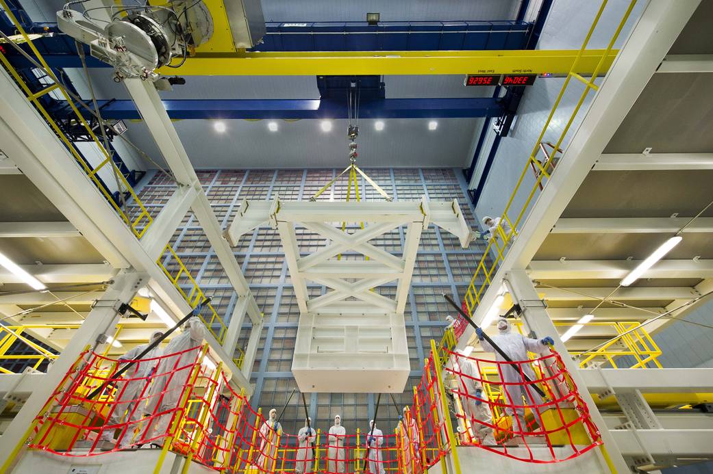 A crane in a clean room at NASA's Goddard Space Flight Center in Greenbelt, Md., lowers a test mass simulator (center of frame) 