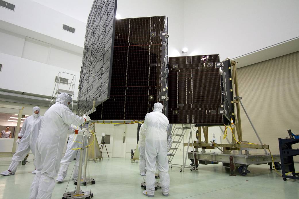 Technicians in the Astrotech payload processing facility in unfurl a solar panel that help power the Juno spacecraft.
