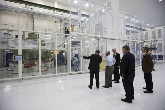 Charles Bolden, NASA administrator, center, is shown the Orion capsule that will make an uncrewed flight test in 2014. 