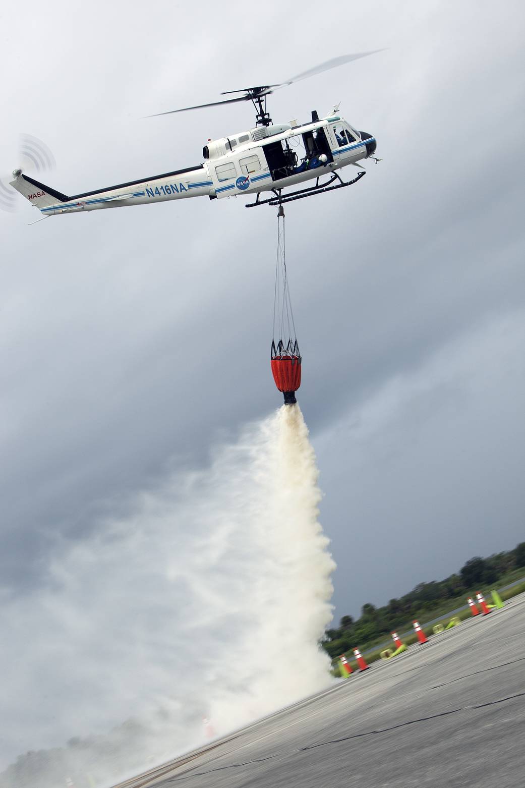 At NASA's Kennedy Space Center in Florida, a three-person helicopter crew recently practiced using a Bambi Bucket to pick up water from a nearby waterway and dropping it on simulated targets at the center’s Shuttle Landing Facility.