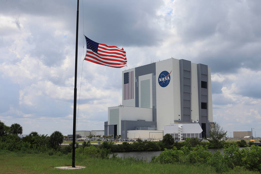 American flag at half staff in front of the Vehicle Assembly Building at Kennedy Space Center
