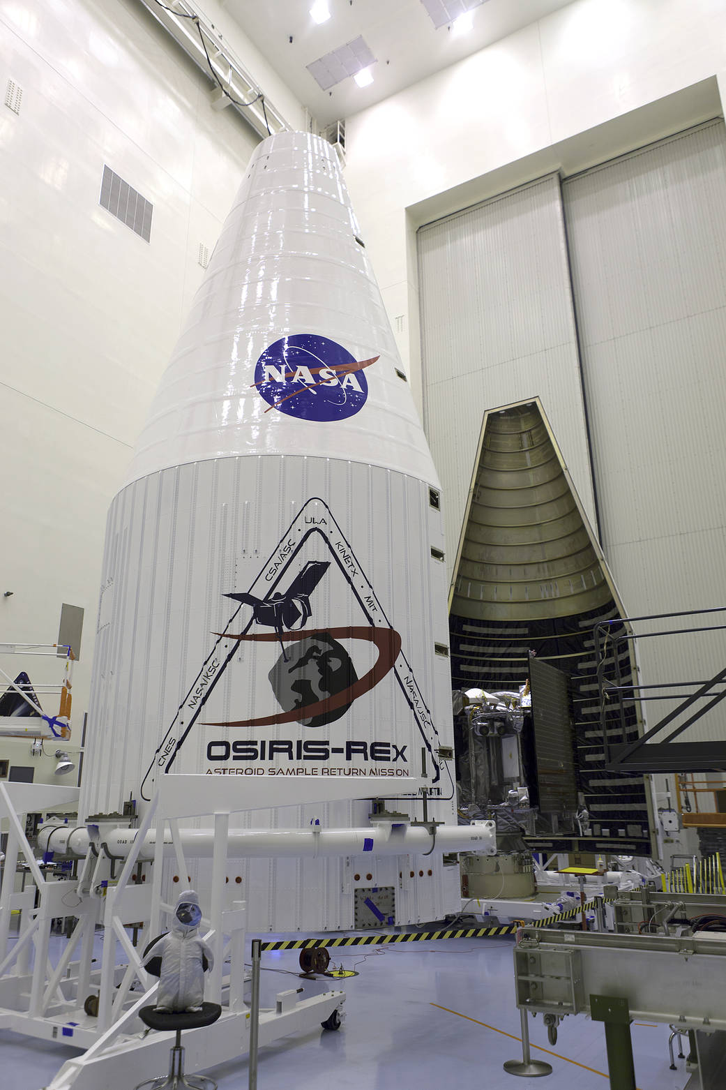 Inside the Payload Hazardous Servicing Facility at NASA's Kennedy Space Center in Florida, the agency’s OSIRIS-REx spacecraft is encapsulated in its payload fairing. 