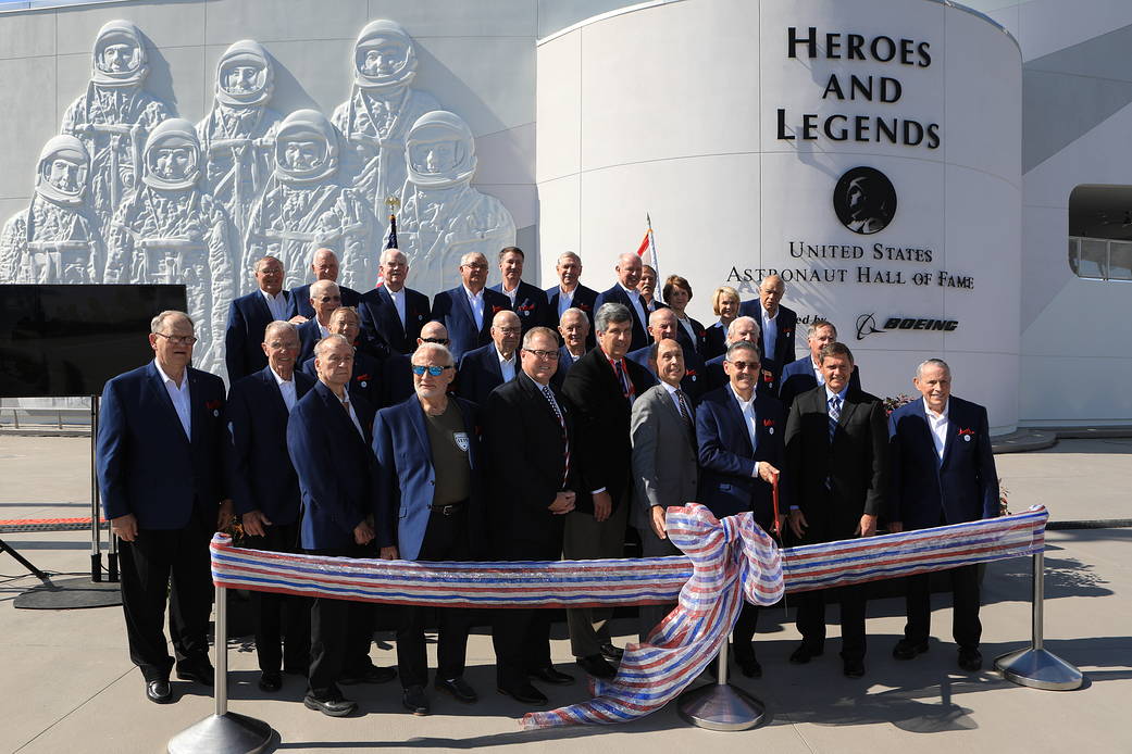 Dignitaries, including members of the U.S. Astronaut Hall of Fame, prepare to cut a ceremonial ribbon opening the Heroes and Legends attraction at the Kennedy Space Center Visitor Complex.