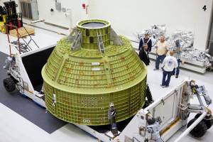 Inside the Neil Armstrong Operations and Checkout Building high bay at NASA's Kennedy Space Center in Florida, the protective covering was removed from the Orion crew module structural test article (STA).