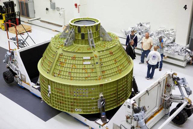 Inside the Neil Armstrong Operations and Checkout Building high bay at NASA's Kennedy Space Center in Florida, the protective covering was removed from the Orion crew module structural test article (STA). 