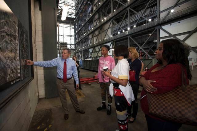Kennedy Space Center Director Bob Cabana points to a display during a tour for cast and crew members of the upcoming motion picture "Hidden Figures." 