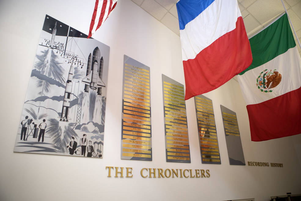 A view of the brass nameplates displaying "The Chroniclers" on the wall at the NASA News Center at Kennedy Space Center in Florida.