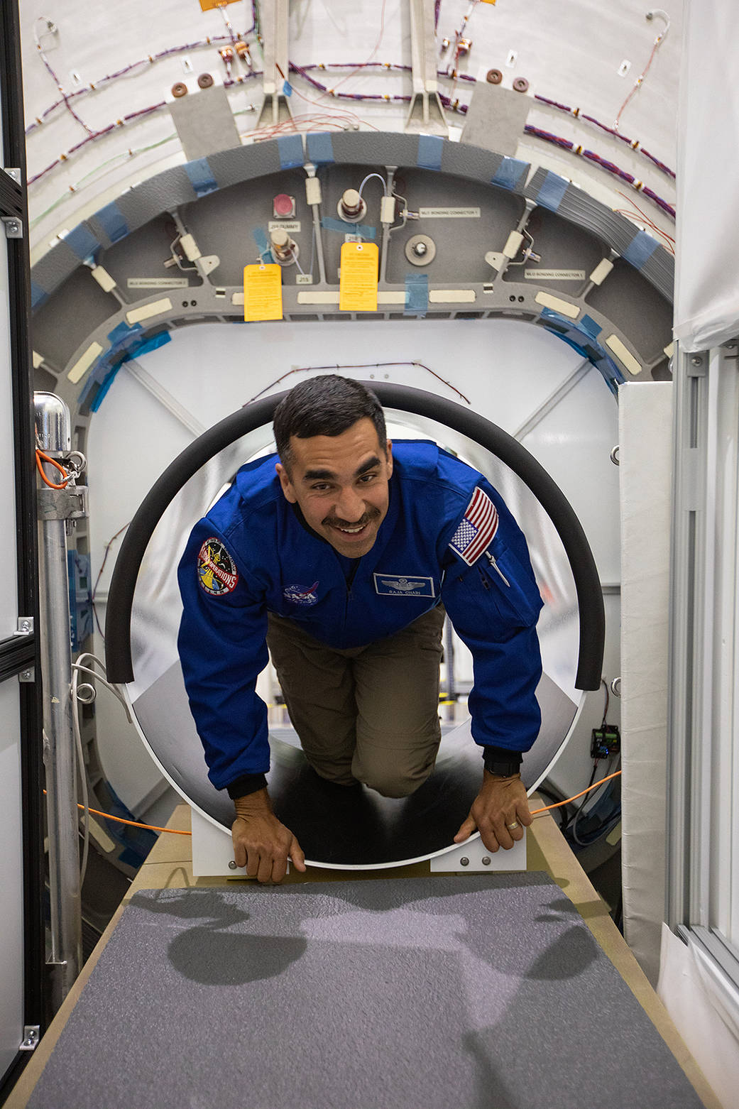 NASA astronaut Raja Chari climbs through a hatch of a Gateway habitat prototype. 