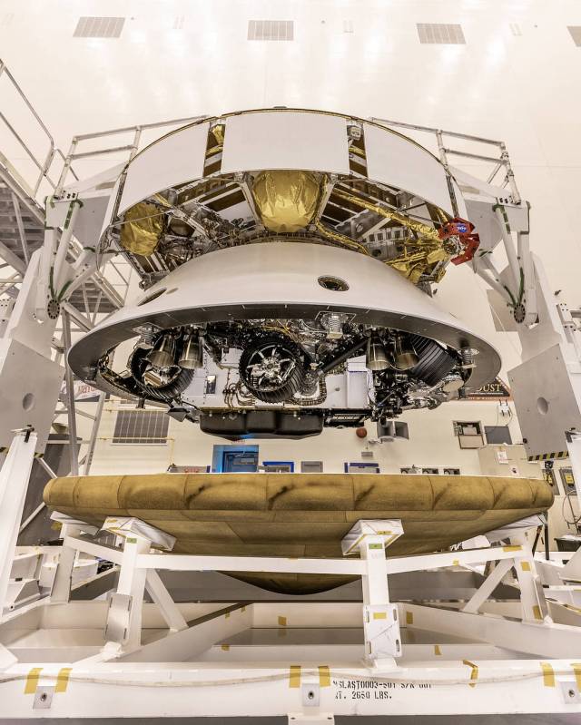 Inside the Payload Hazardous Servicing Facility at NASA’s Kennedy Space Center in Florida, the Backshell-Powered Descent Vehicle and Entry Vehicle assemblies are being attached to the Mars Perseverance rover on May 28, 2020.
