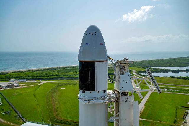 Seen here is an up-close view of the SpaceX Dragon spacecraft atop the company’s Falcon 9 rocket after being raised to a vertical position at the launch pad in preparation for the 23rd resupply services mission.