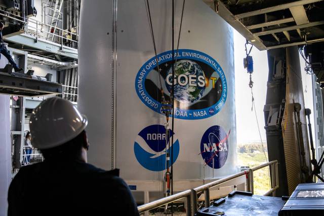 A United Launch Alliance technician monitors the progress as the NOAA's Geostationary Operational Environmental Satellite-T, enclosed in its payload fairing, moves into the Vertical Integration Facility.
