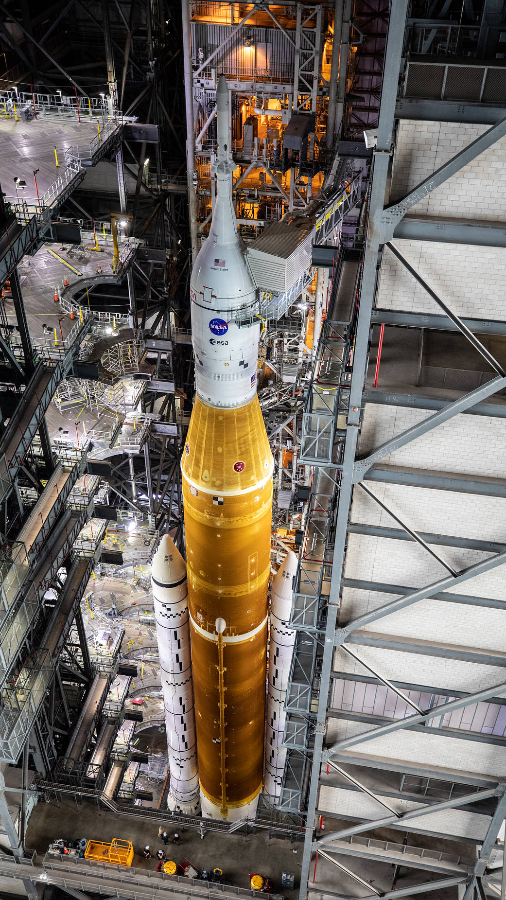 In this view looking down in High Bay 3 of the Vehicle Assembly Building at Kennedy Space Center, all of the work platforms that surround the Artemis I Space Launch System and Orion spacecraft are fully retracted.