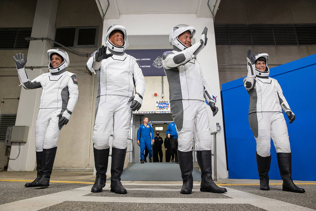 Crew-4 astronauts wave after walking out through the double doors below the Neil A. Armstrong Building’s Astronaut Crew Quarters at NASA’s Kenn...