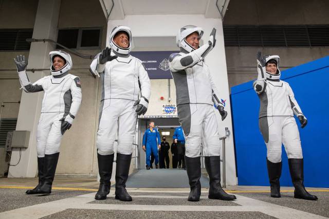 Crew-4 astronauts wave after walking out through the double doors below the Neil A. Armstrong Building’s Astronaut Crew Quarters at NASA’s Kennedy Space Center in Florida on April 27, 2022. 