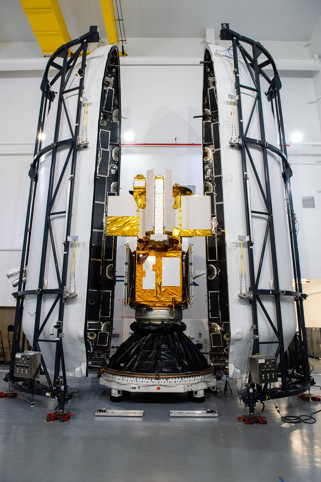 Inside the SpaceX facility at Vandenberg Space Force Base in California, both halves of the SpaceX Falcon 9 payload fairing are moved to enclose the Surface Water and Ocean Topography (SWOT) satellite on Dec. 8, 2022. 