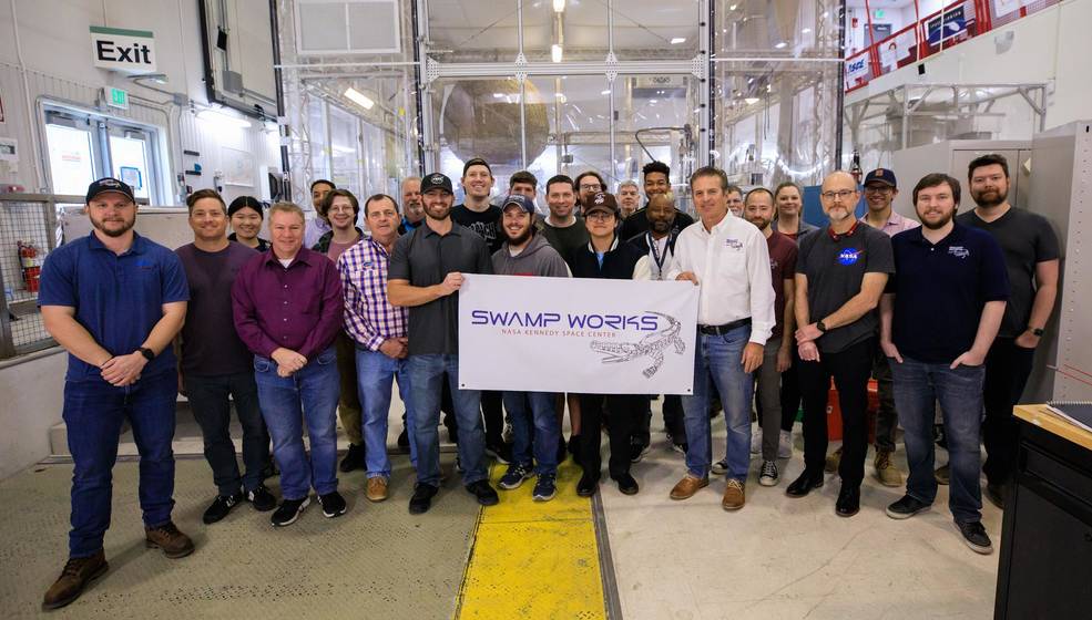 Groups from the Granular Mechanics and Regolith Operations laboratory and the Electrostatics and Surface Physics Laboratory gather for a photograph to celebrate the 10th anniversary of Swamp Works at Kennedy Space Center in Florida on Feb. 13, 2023. 