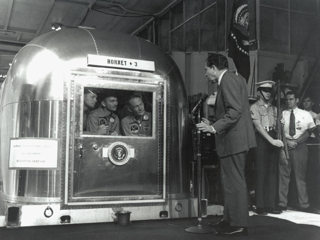 The Apollo 11 astronauts inside the Mobile Quarantine Facility aboard the USS Hornet.