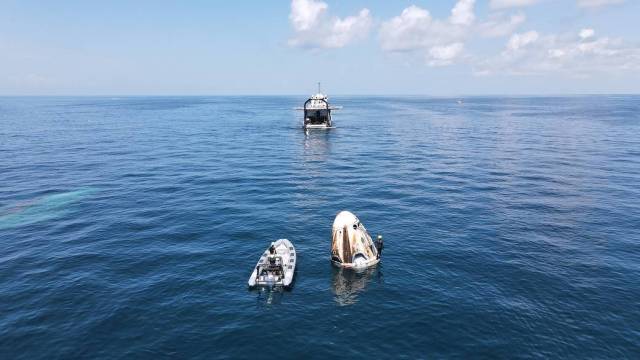 Support teams arrive at the SpaceX Crew Dragon spacecraft, with NASA astronauts Robert Behnken and Douglas Hurley onboard, shortly after it splashed down in the Gulf of Mexico.