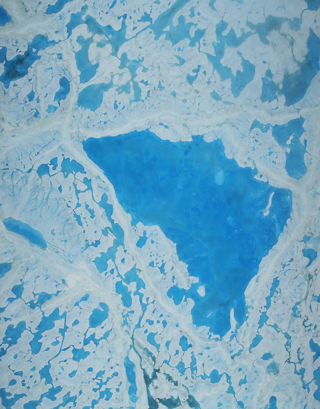 overhead view of sea ice with a large melt pond
