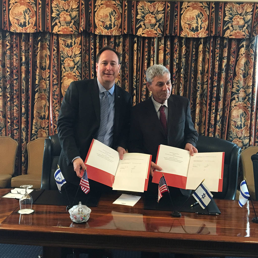 Acting Administrator Lightfoot and Director General Avi Blasberger hold signed agreement
