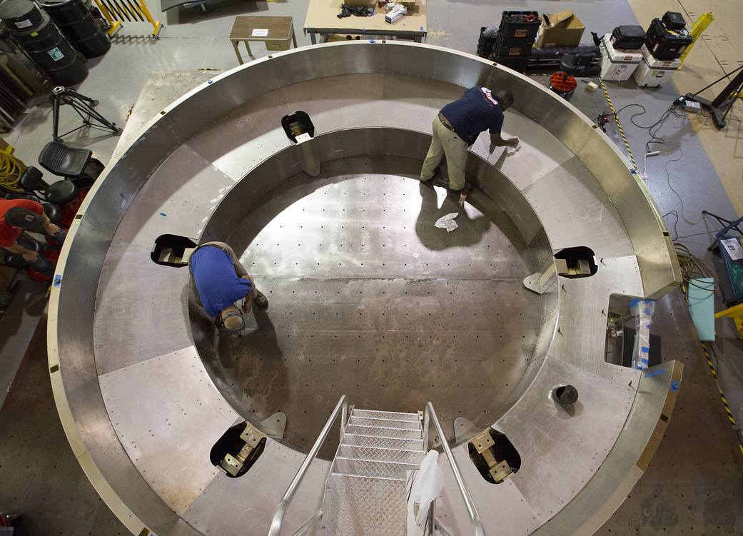 Two NASA Langley team members finish work on the Orion AA-2 separation ring.