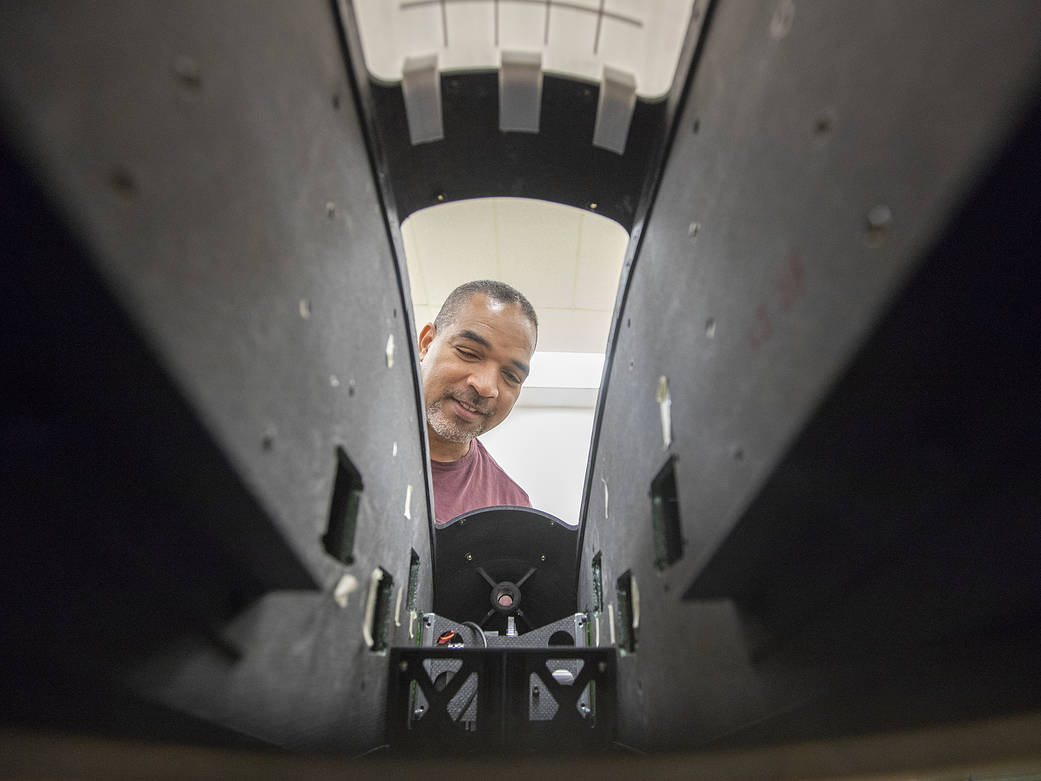 Langley engineering technician Sam James looks inside a full-scale model of Langley Aerodrome No. 8.