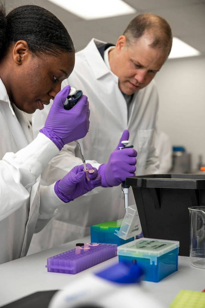 NASA Administrator Jim Bridenstine helps student conduct an experiment.