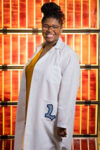 Engineer Lyndsey McMillon-Brown stands in front of solar cells at NASA’s Glenn Research Center.