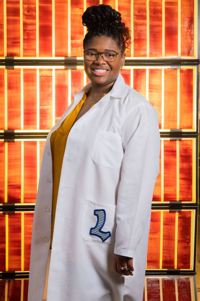 Engineer Lyndsey McMillon-Brown stands in front of solar cells at NASA’s Glenn Research Center. 