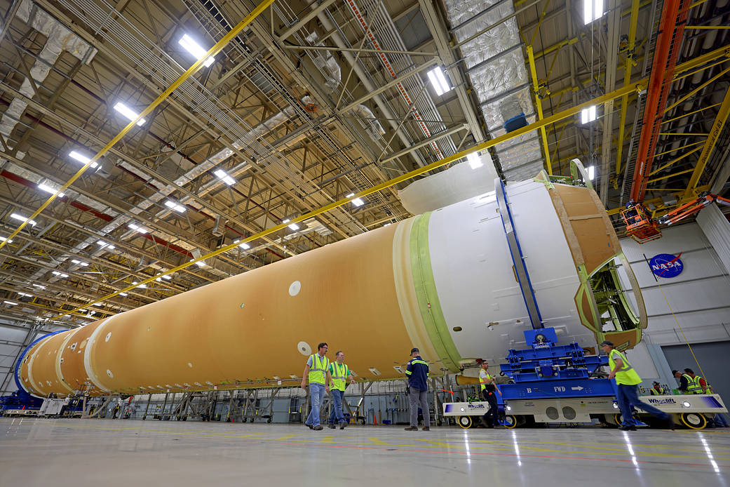 Following the join of the engine section, the core stage of NASA’s Space Launch System rocket for the Artemis II mission lies in a horizontal position at the agency’s Michoud Assembly Facility. Technicians are seen working beside the 212-foot-tall stage. 