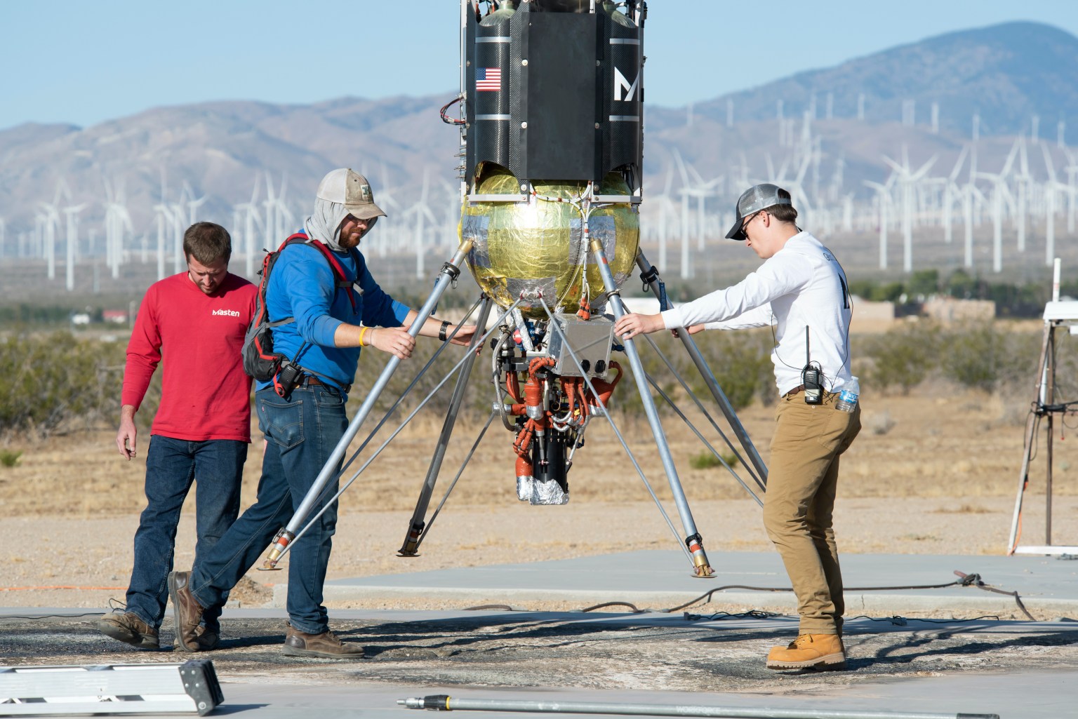 Researchers examine their payload attached to the Masten Xodiac vehicle. (from solicitations archive)