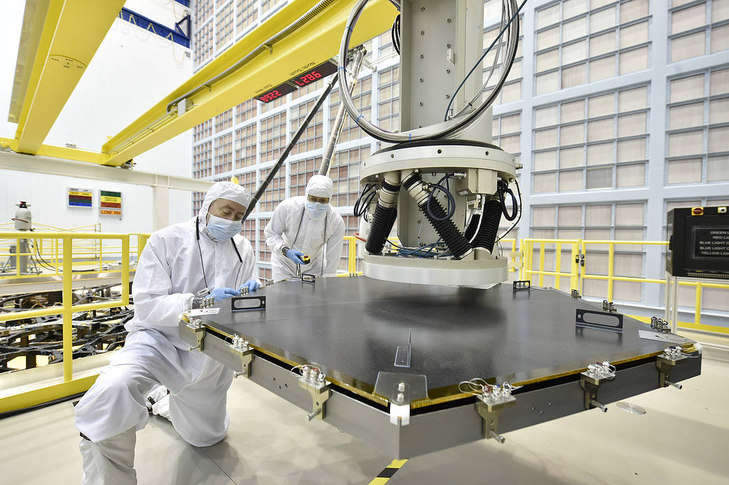 A primary mirror segment (black hexagonal shape) from the James Webb Space Telescope was mounted on a grey/silver robotic arm.