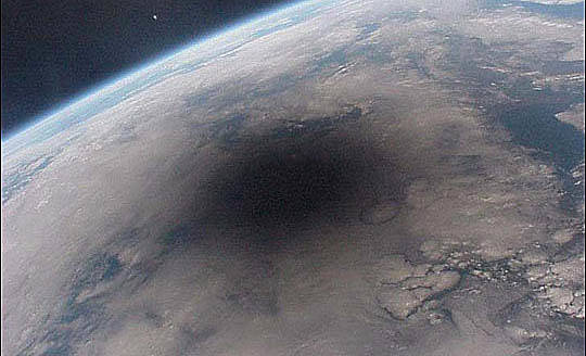 A large shadow on the surface of Earth as seen from space