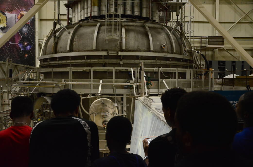 students stand in awe of giant vacuum chamber