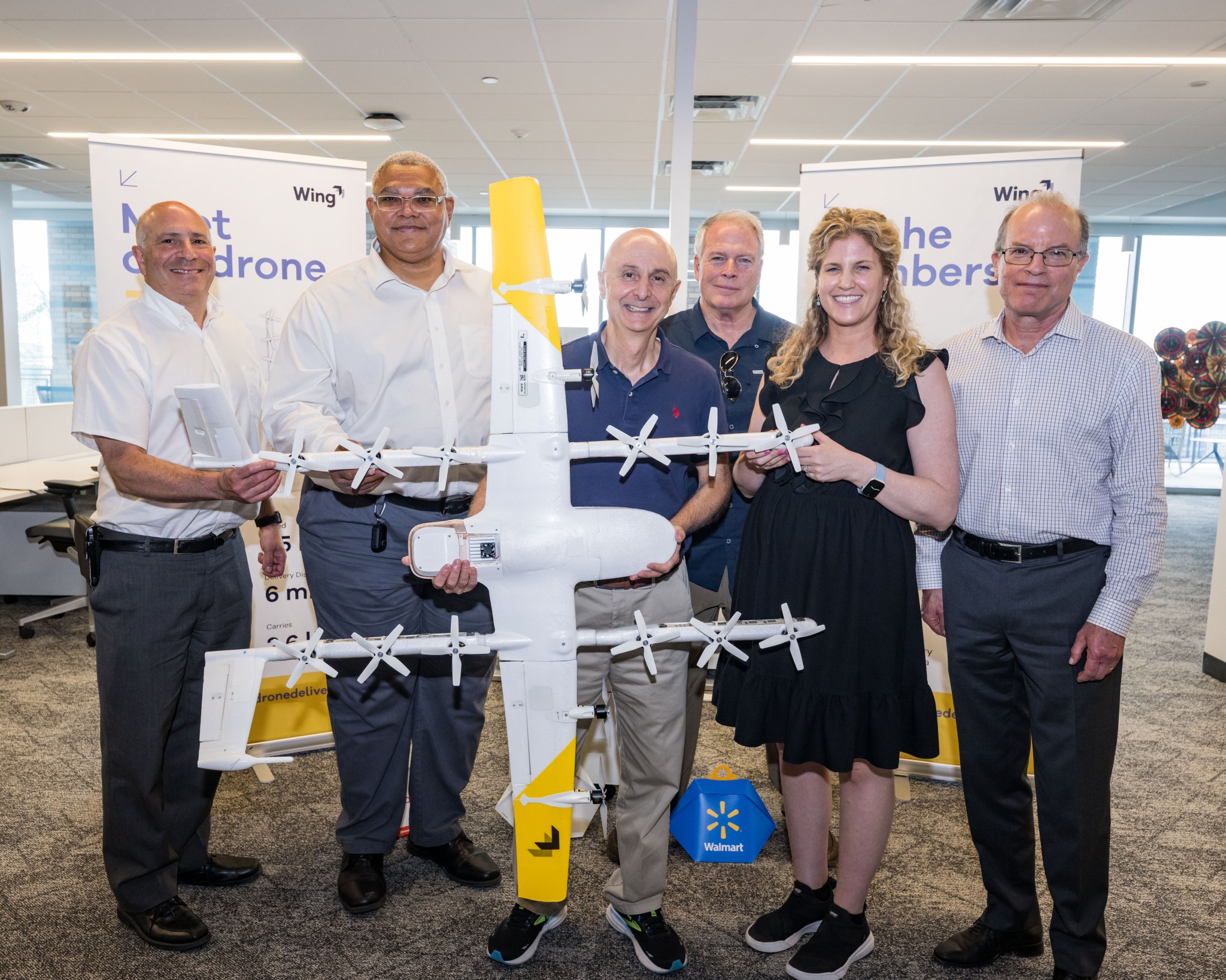 NAC Aeronautics Committee members standing next to a large drone model with yellow tipped wings.
